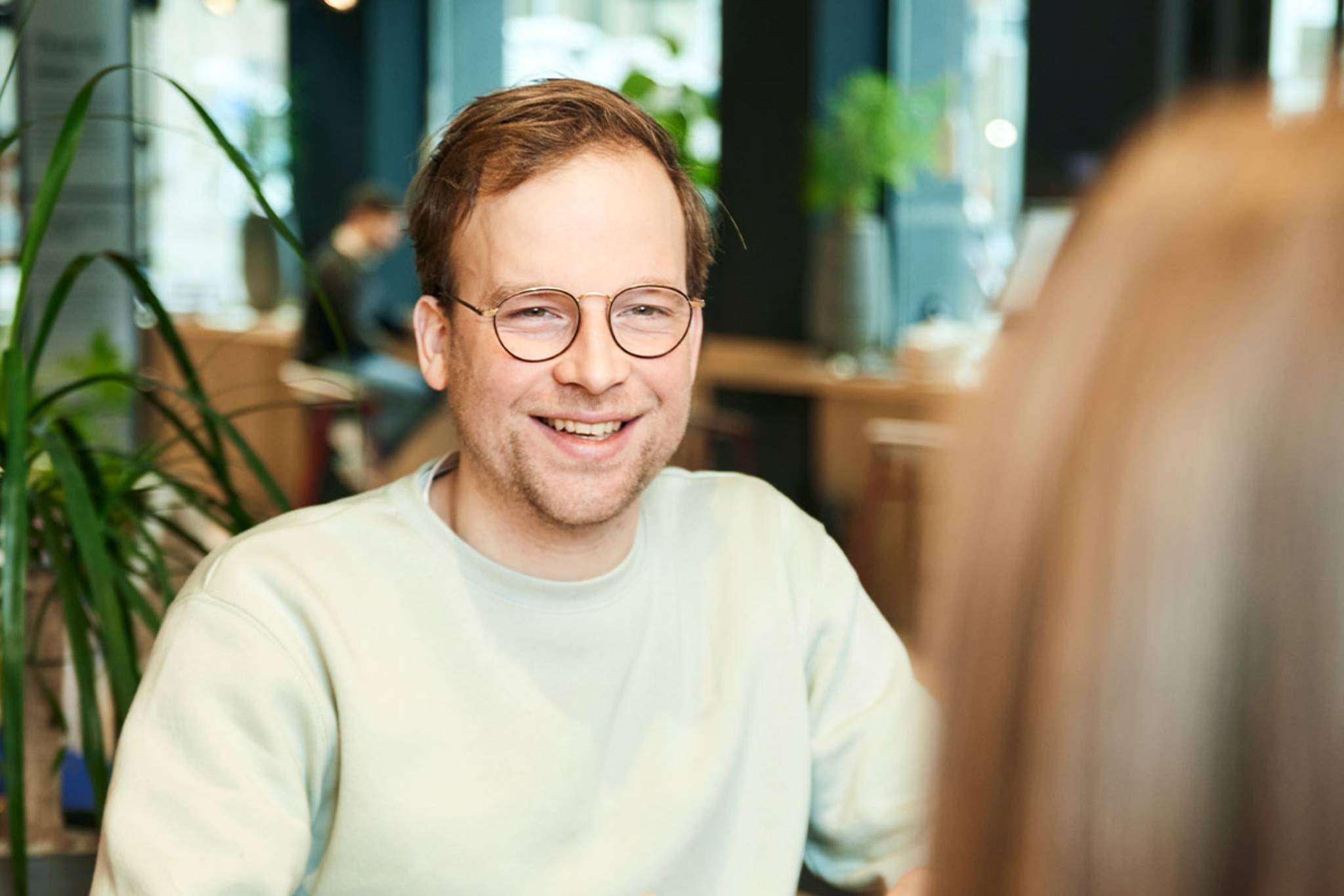 Man lachend naar collega.