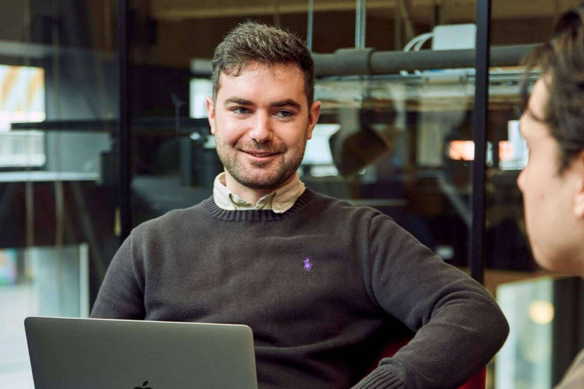 Man lachend naar collega.